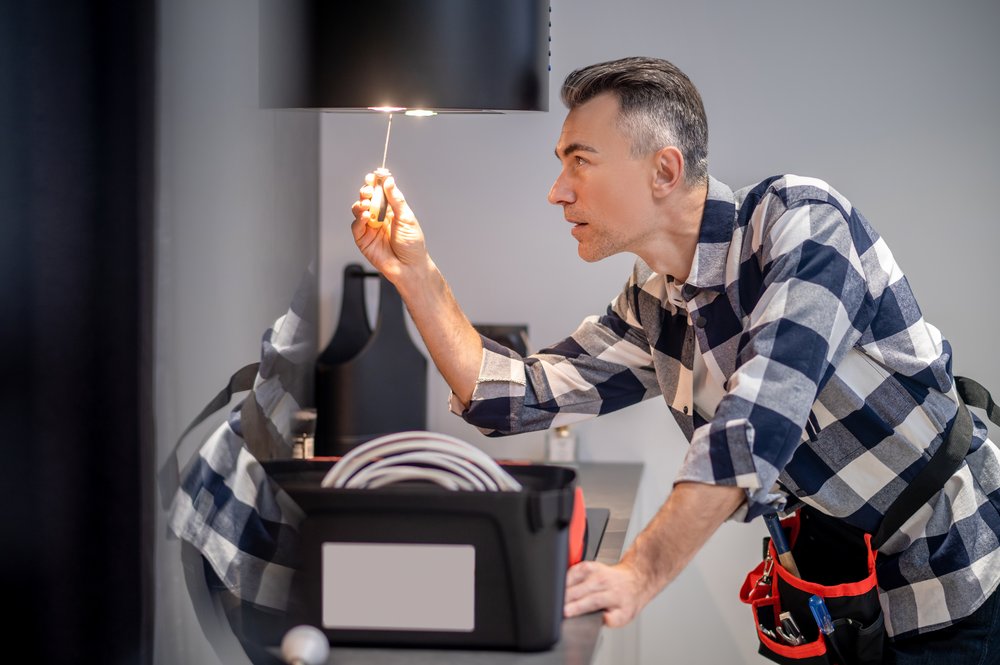 concentrated- man touching screwdriver lamp kitchen